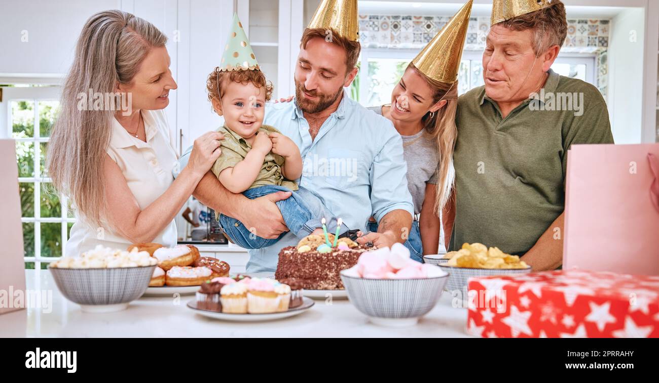 Bambini, famiglia e compleanno con genitori e nonni per celebrare la festa di un ragazzo insieme in casa. Torta, celebrazione ed evento con un mese Foto Stock