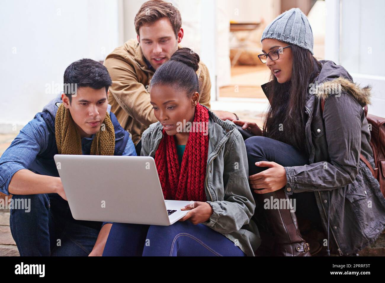 Lavorare insieme al loro progetto di ricerca. Studenti universitari che utilizzano un computer portatile mentre si siedono nel campus. Foto Stock