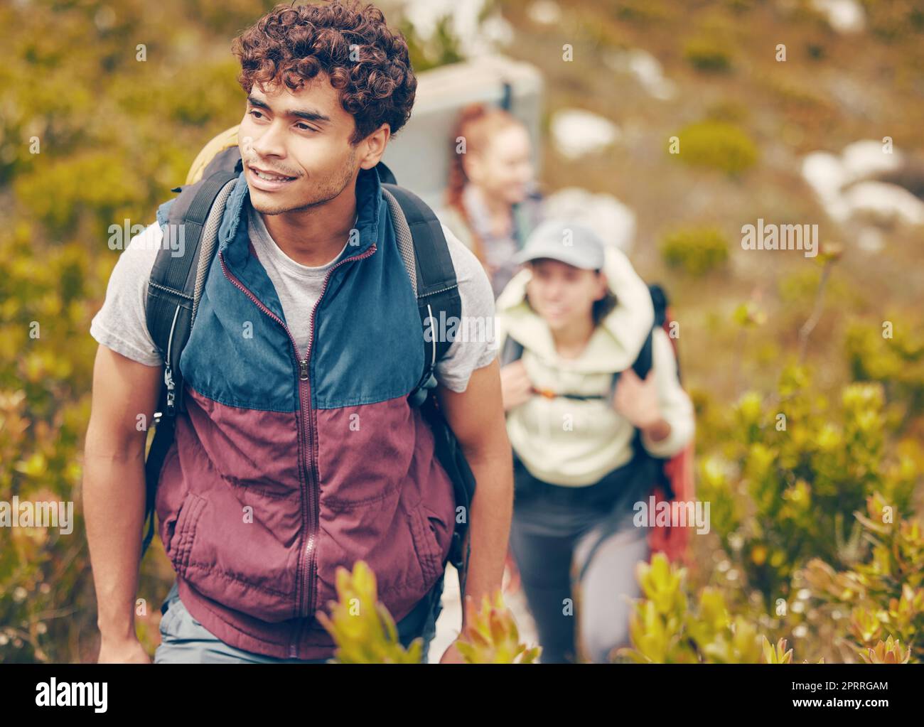 Escursioni, amici e avventura con un gruppo di giovani che indossano zaini durante il viaggio, l'avventura e il viaggio nella natura. Attività fisica, fitness ed esercizio con un uomo felice trekking da esplorare con gli amici Foto Stock