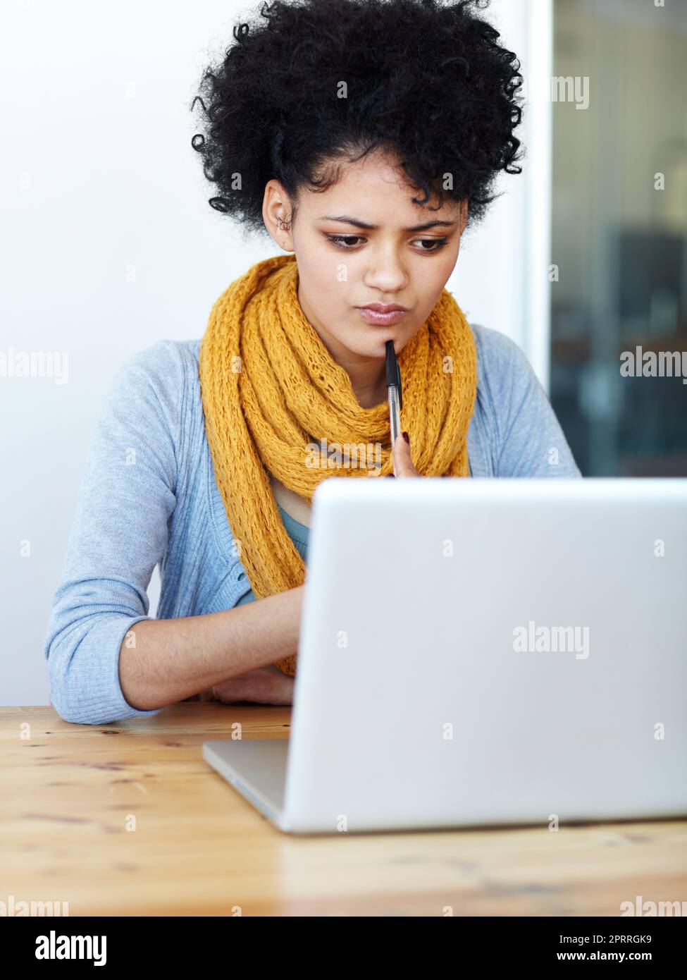 Completamento di un'attività online. Una giovane donna attraente seduta al suo laptop. Foto Stock