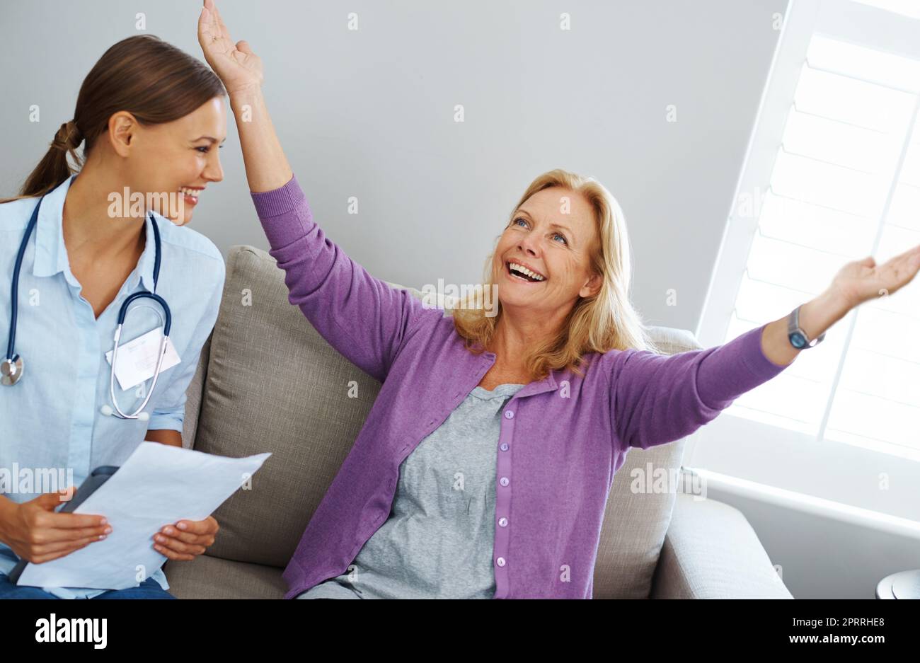 Sapevo che le mele avrebbero pagato, una donna anziana che celebra i risultati ottenuti dalla sua infermiera. Foto Stock