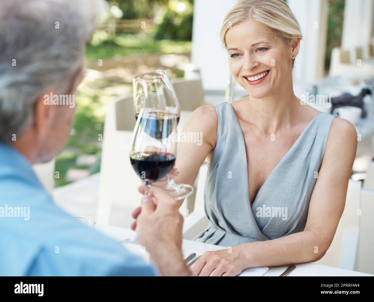 Eroe al nostro amore. Felice coppia matura brindando il loro amore con due bicchieri di vino mentre all'aperto. Foto Stock