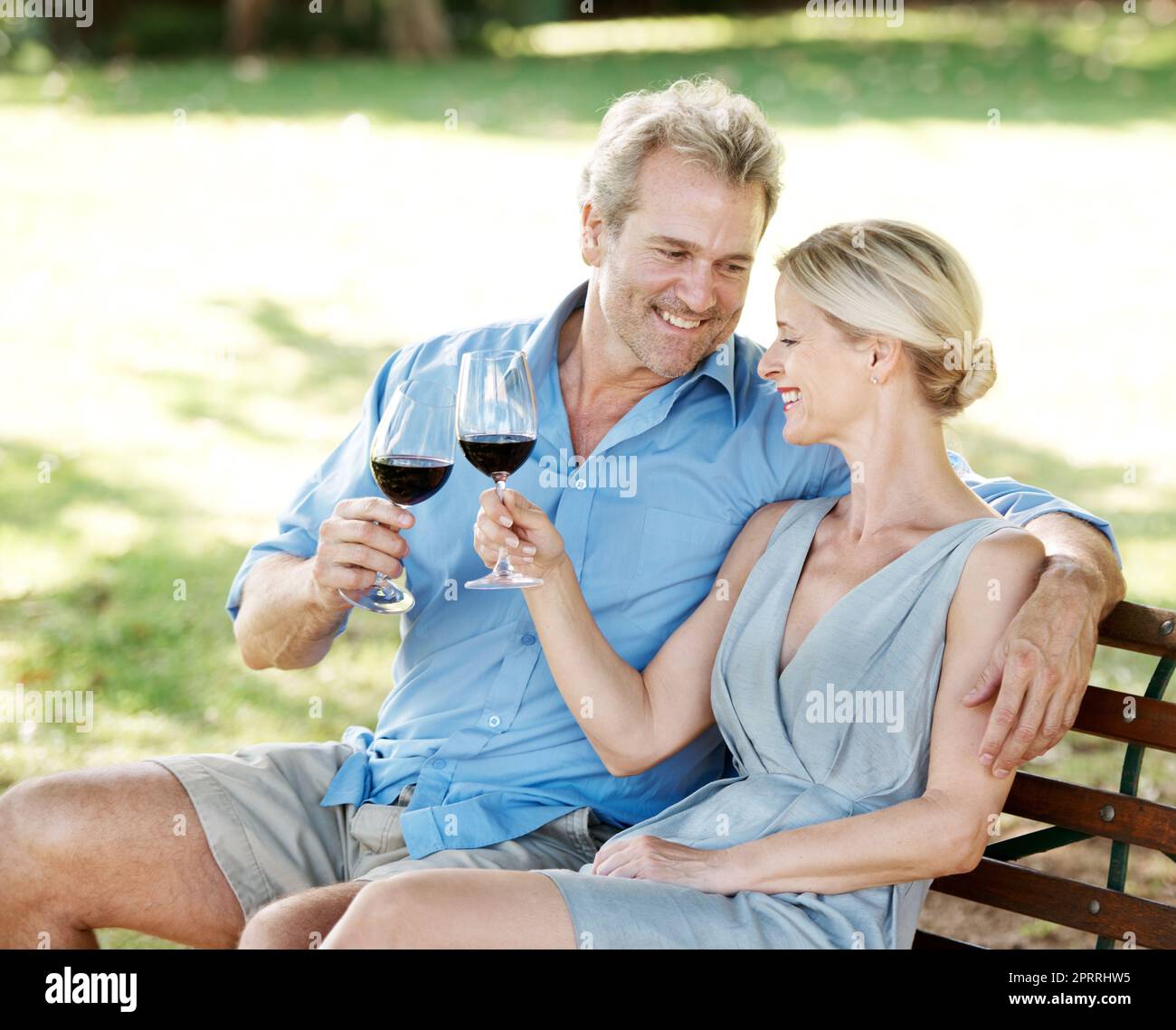 Diraspare insieme. Felice coppia matura brindando il loro amore con due bicchieri di vino mentre all'aperto. Foto Stock