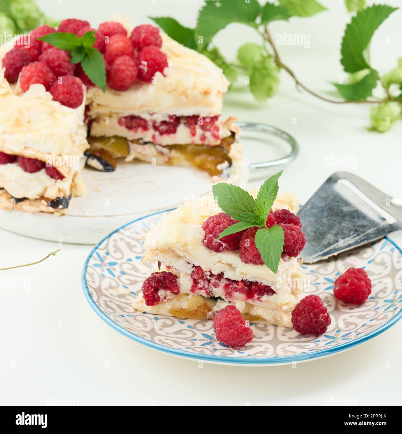 Torta di meringa rotonda con lamponi freschi su sfondo bianco, Pavlova dessert Foto Stock