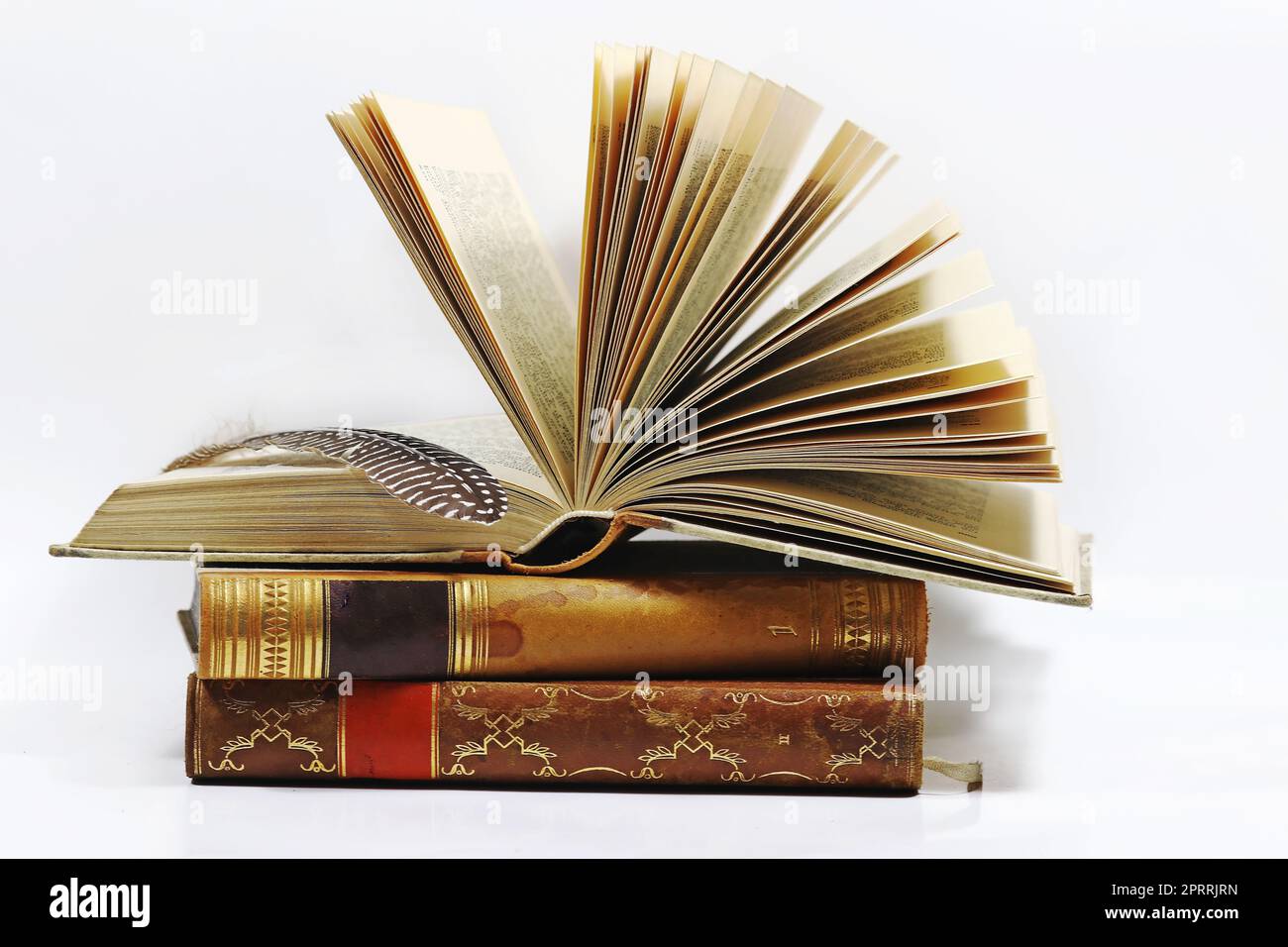 Tre vecchi libri e una penna su sfondo bianco Foto Stock