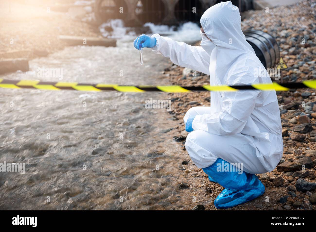 Ecologista che campiona l'acqua dal fiume con una provetta Foto Stock