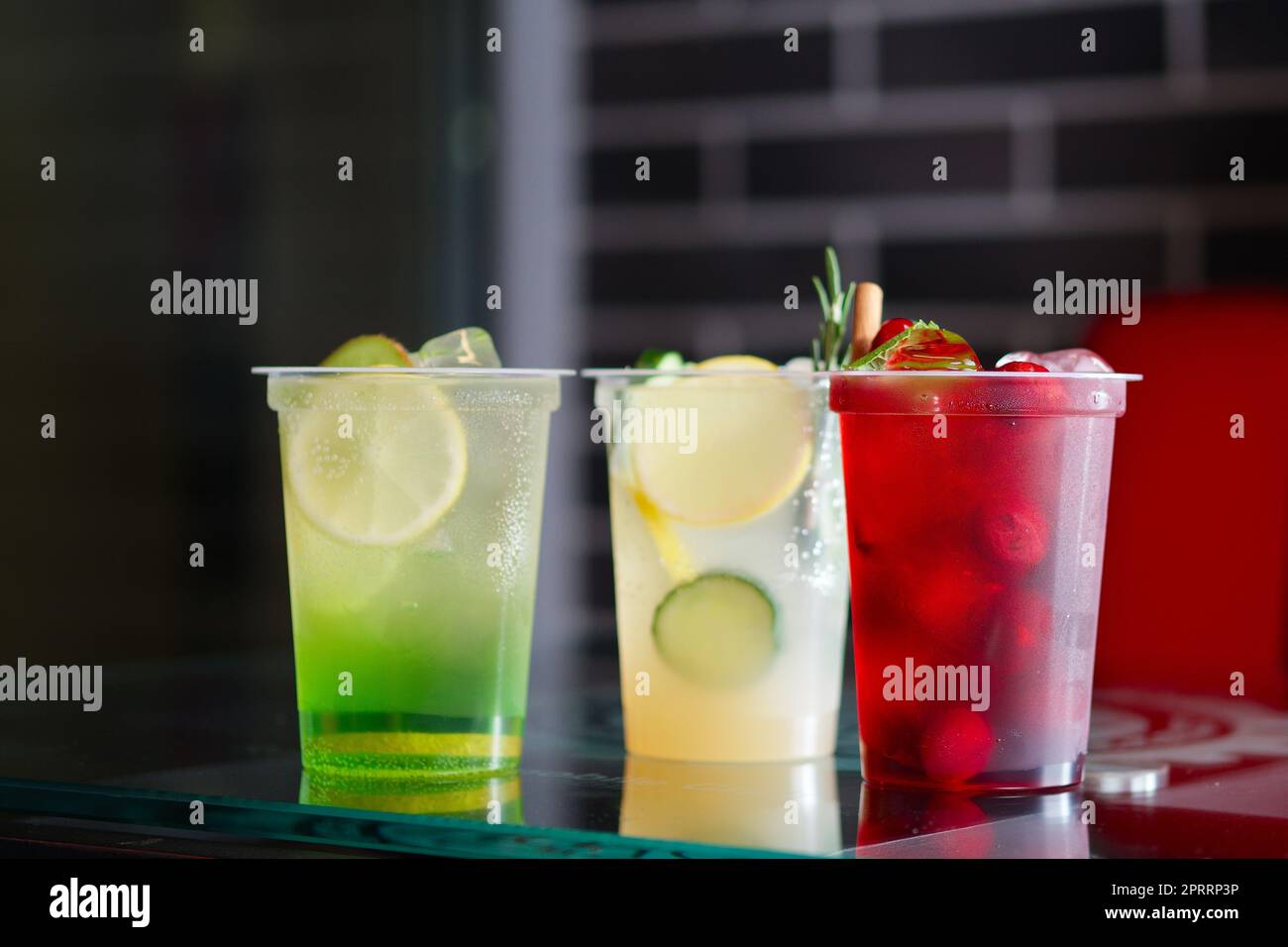 Tre bicchieri con limonata fresca su un tavolo di vetro Foto Stock