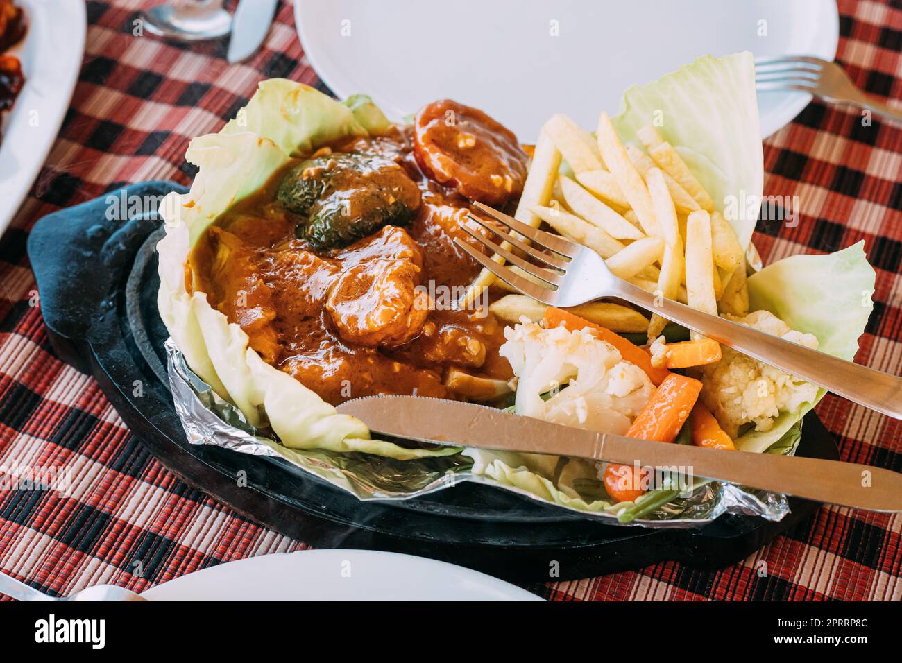 Goa, India. Il piatto della cucina nazionale indiana è il Sizzler, composto da patatine fritte, gamberi fritti in salsa e verdure fritte. Piatto tradizionale di Goa Foto Stock