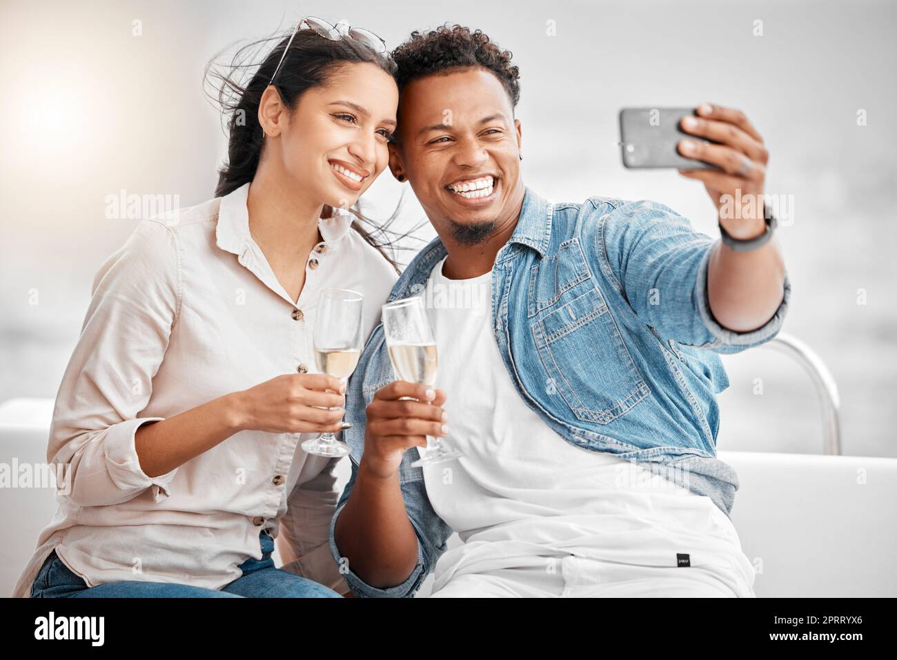 Selfie di coppia, crociera in barca di lusso e bicchiere di champagne per festeggiare l'anniversario, la luna di miele e l'amore a Miami, Florida. Uomo felice, donna sorridente e foto di feste in yacht, viaggio e relax in mare estivo Foto Stock