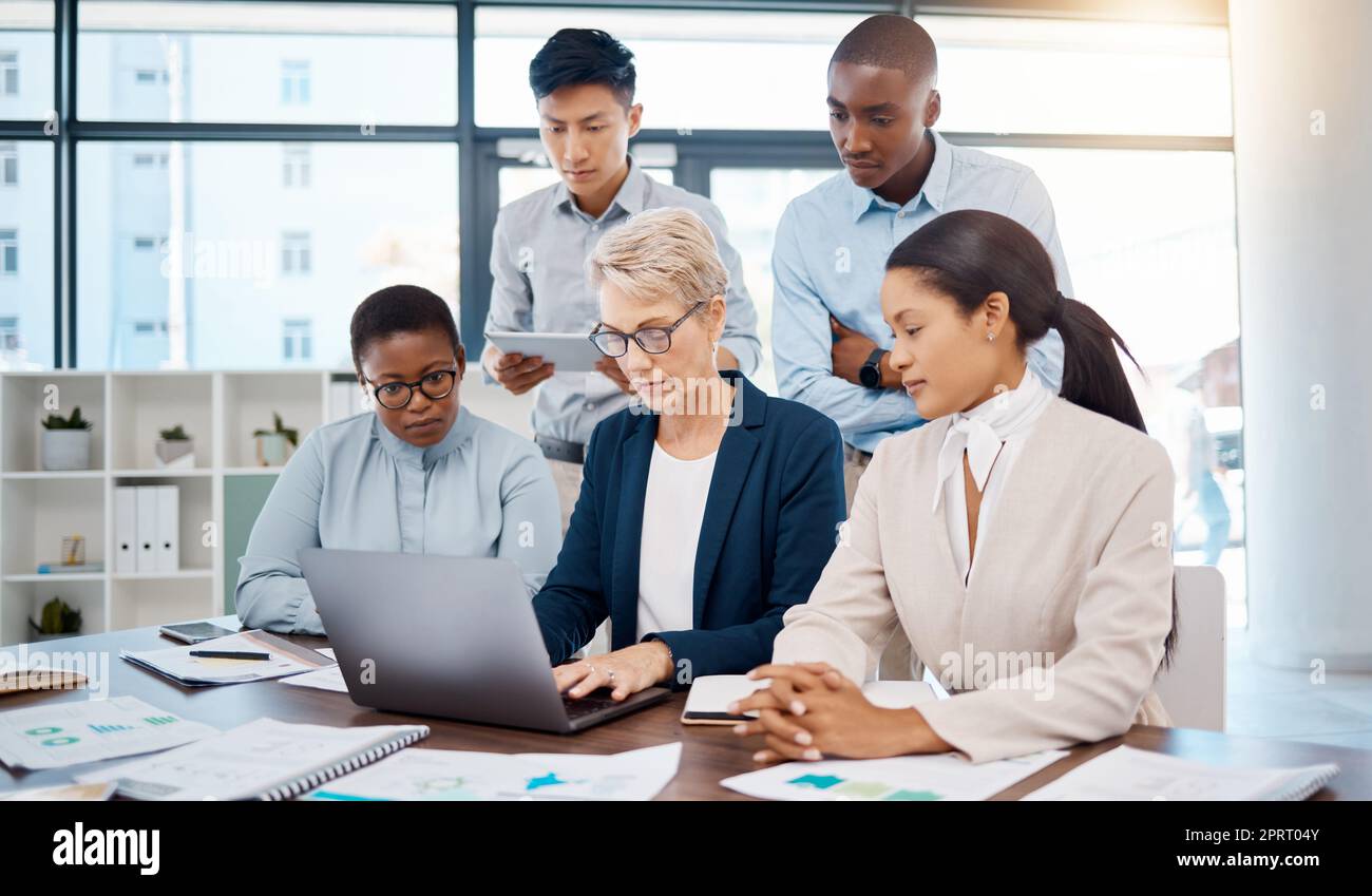 Riunione per manager, laptop e collaborazione per team che lavorano nel marketing digitale e nella pubblicità. Leadership, pianificazione e strategia per il gruppo Diversity con ceo, documenti cartacei e statistiche grafiche Foto Stock