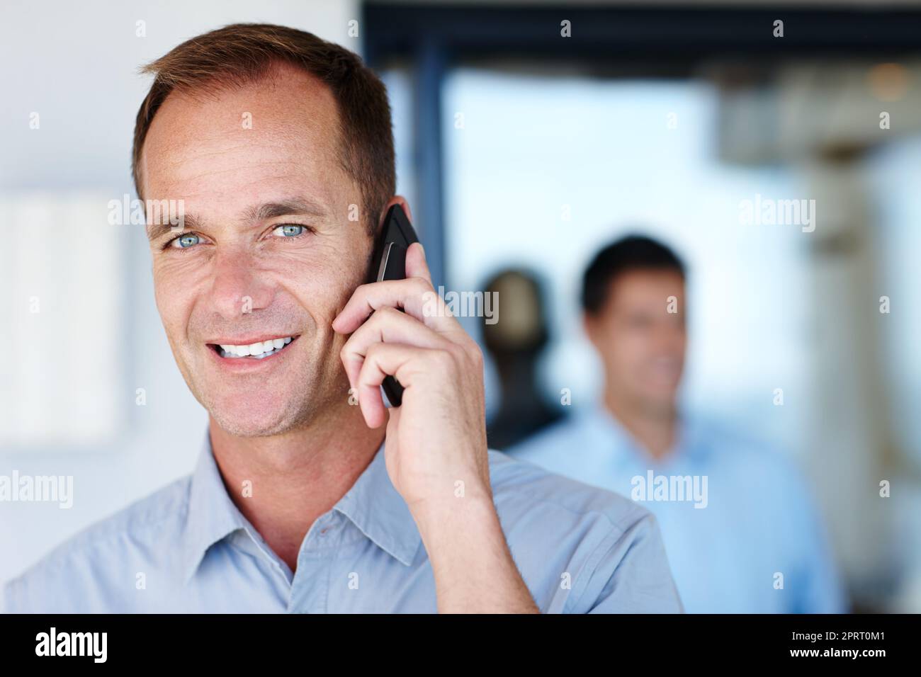 Essere wireless è meraviglioso. Ritratto di un lavoratore maturo che effettua telefonate dall'ufficio. Foto Stock