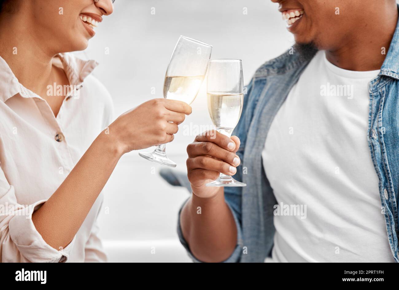 Festeggiate, brindate e coppie con champagne per anniversario, data o vacanza di lusso insieme. Amore, saluti e mani felici di uomo e donna che tengono un bicchiere di vino per gioia, bere ed eventi Foto Stock
