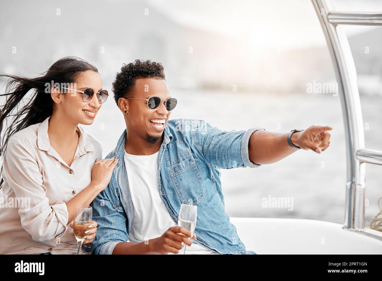 Le coppie amano viaggiare su uno yacht di lusso in mare insieme in un romantico appuntamento nella natura in una vacanza. Sorridi, fidanzato e donna felice e giovane si godono lo champagne nell'oceano in una crociera in barca Foto Stock