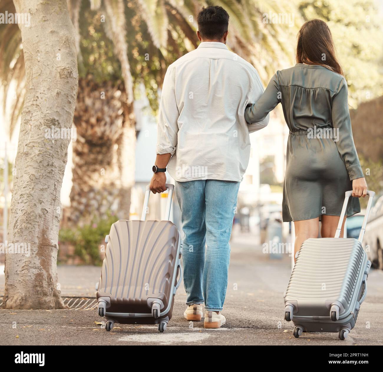 Coppia, cammina e viaggia con i bagagli in vacanza per la luna di miele in città all'estero. Uomo e donna sposati durante le vacanze estive internazionali con le borse mentre camminano lungo una strada per l'alloggio Foto Stock