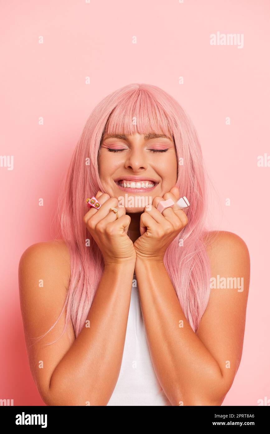Un modello molto felice e bella ragazza, con capelli rosa in piedi con gli occhi chiusi e pugni premuti contro il suo volto, felice di vincere la lotteria, fortunato ch Foto Stock