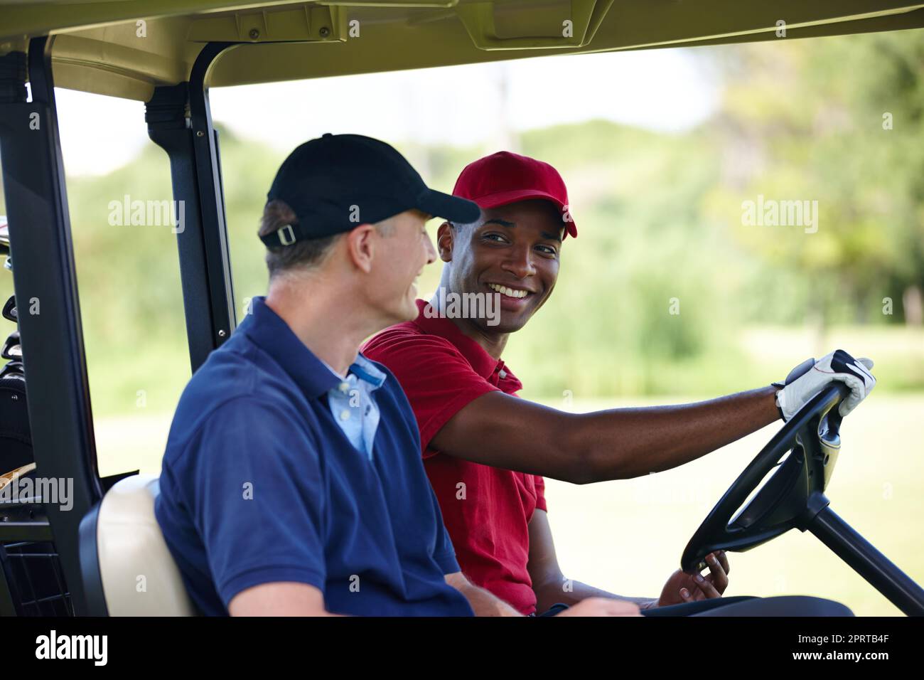 Perché camminare quando si può guidare. Due uomini felici che guida un golf cart su un campo da golf. Foto Stock