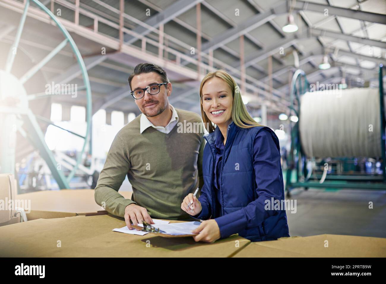 Gestione delle operazioni in magazzino. Ritratto di due manager che leggono documenti mentre si trovano in fabbrica. Foto Stock