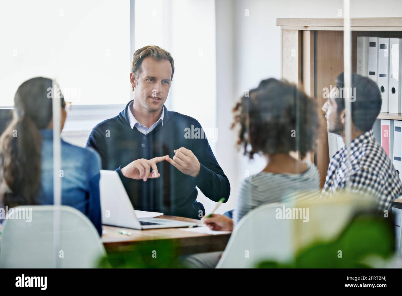 Assegnazione di compiti. Quattro giovani designer che hanno una riunione d'affari. Foto Stock