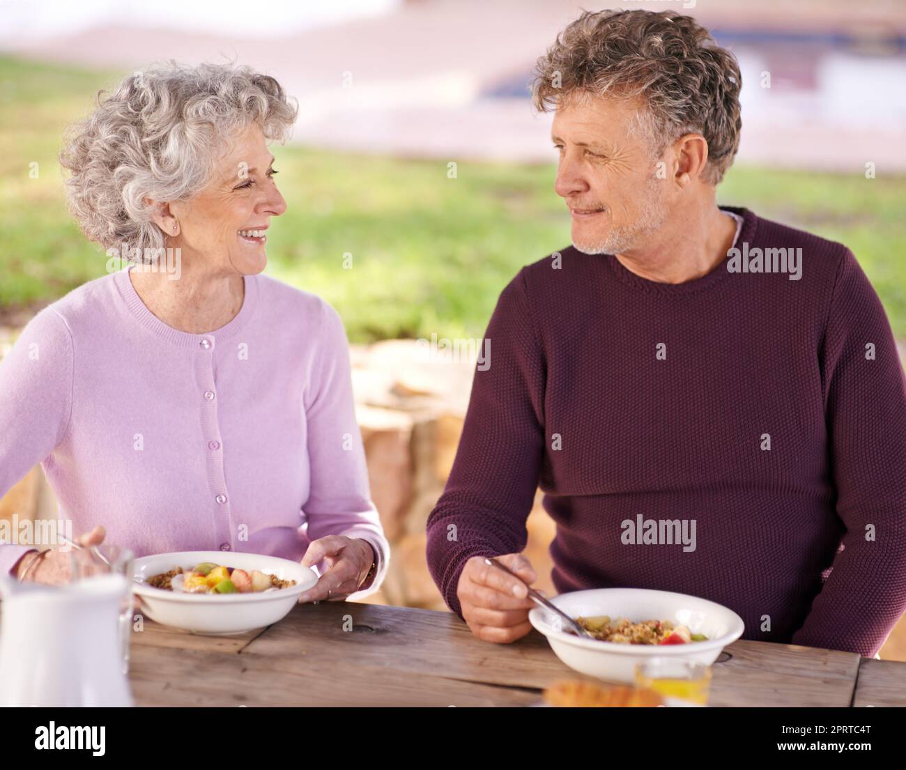 La colazione è un po' affettuosa, una coppia anziana che ha fatto colazione all'aperto. Foto Stock