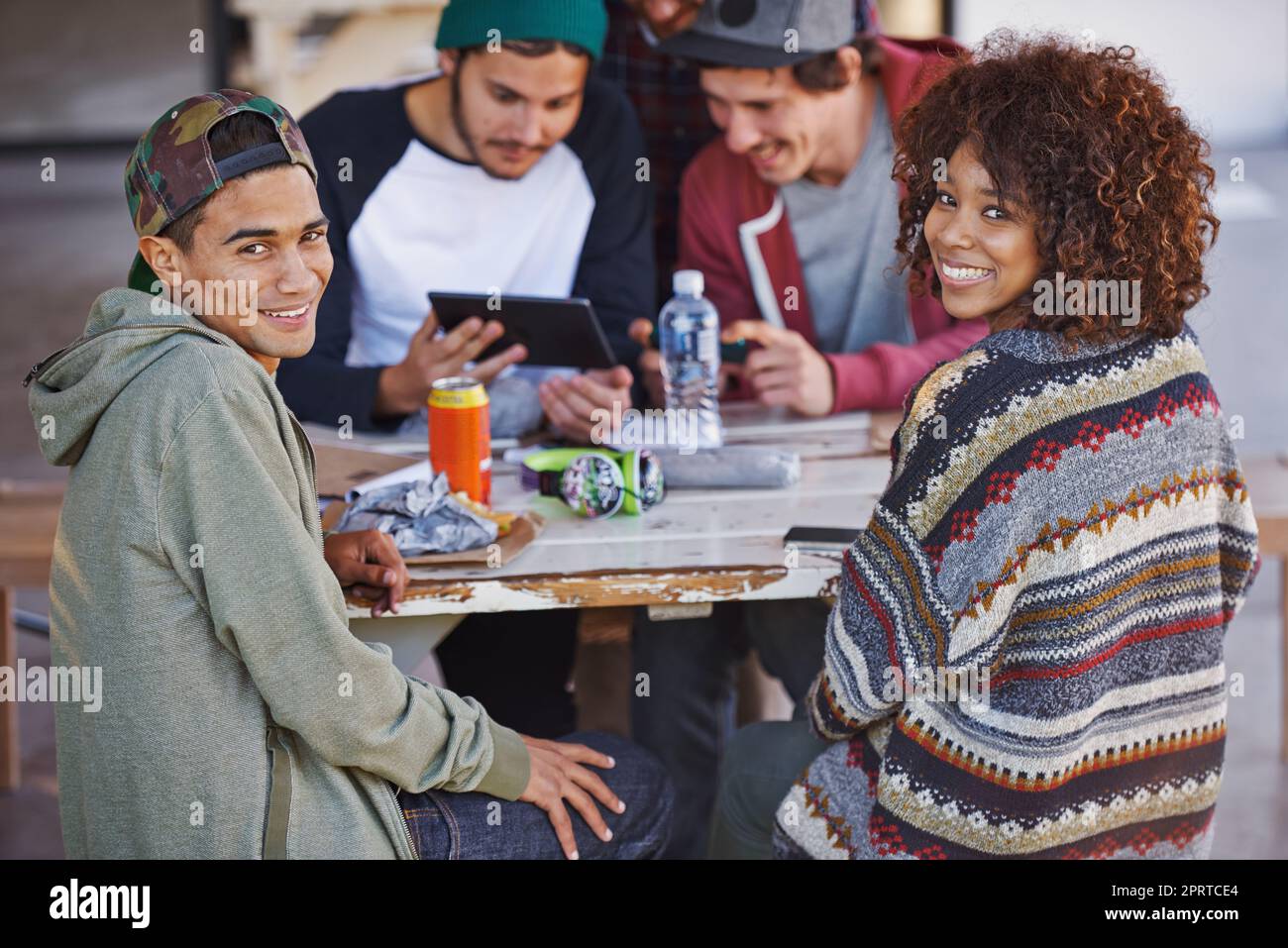 Erano proprio a casa nel campus. Un gruppo di amici intorno ad un tavolo all'aperto. Foto Stock