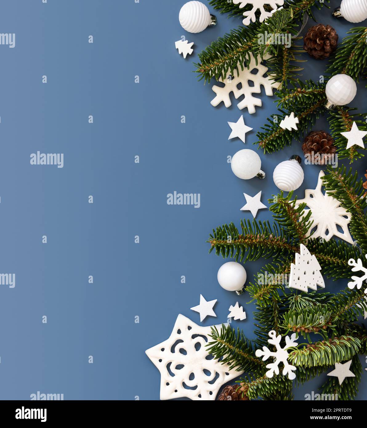 Decorazioni natalizie bianche e rami di abete su una vista dall'alto blu con spazio per le copie Foto Stock