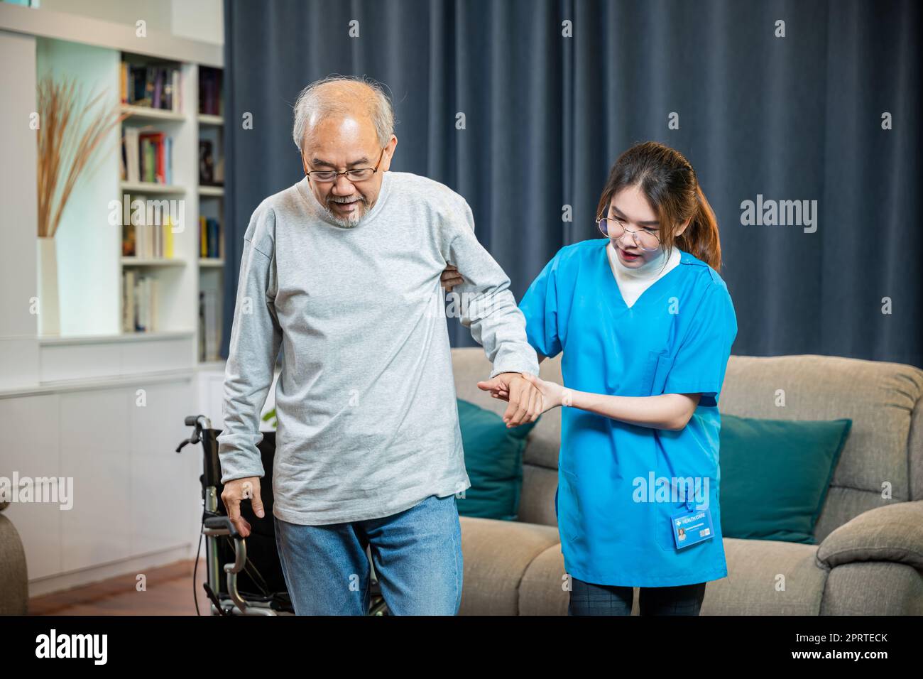Il medico asiatico sostiene il vecchio ad alzarsi per l'esercizio fisico Foto Stock