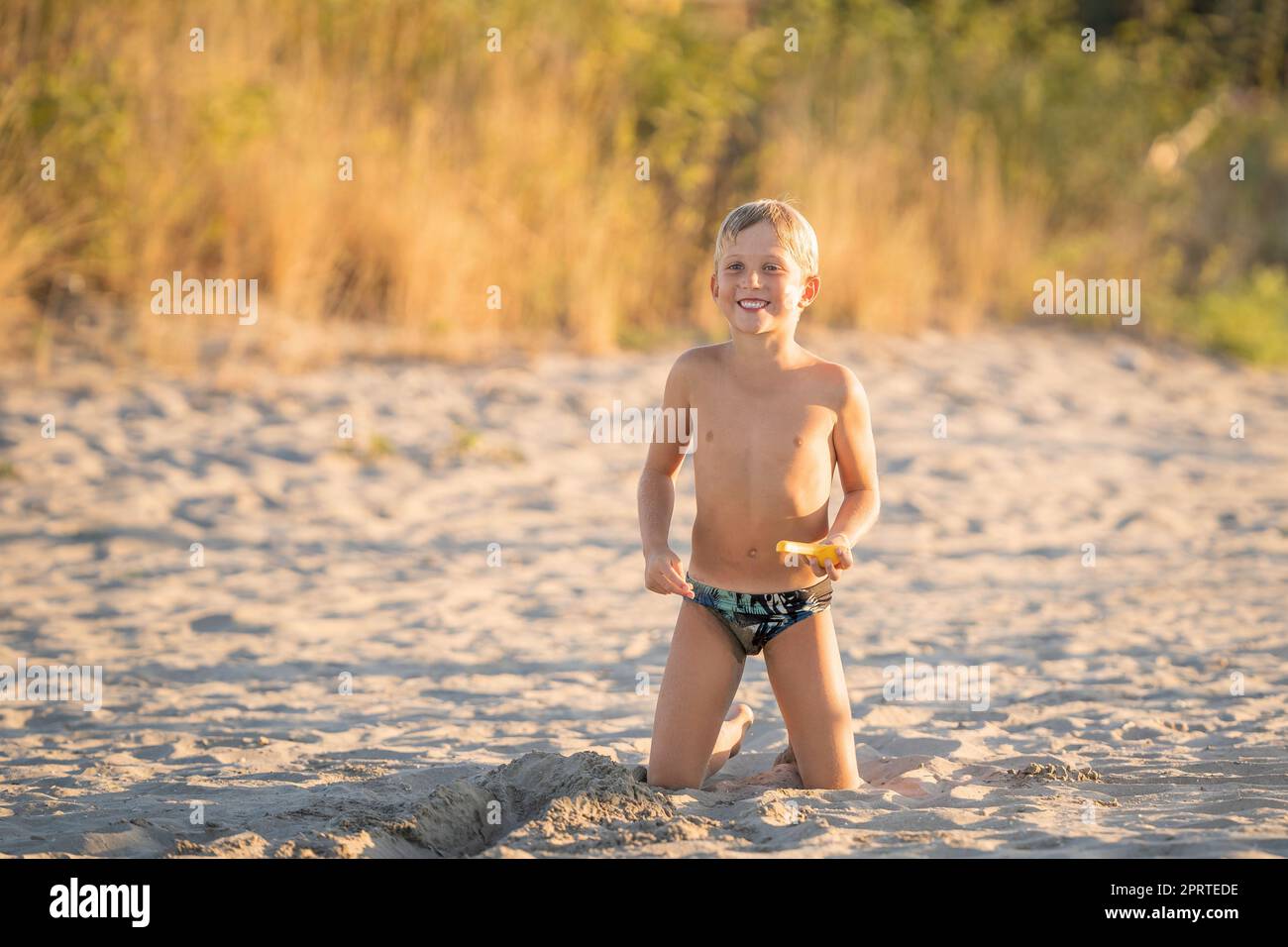 Ritrarre il bambino sorridente sulla spiaggia durante le vacanze estive Foto Stock