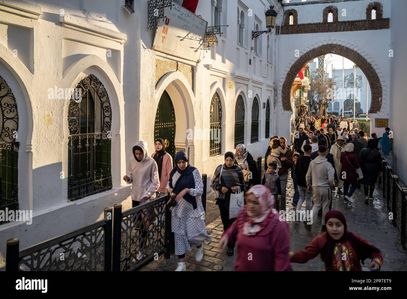 Persone che passeggiando per una strada trafficata nella medina Tetouan al tramonto. Foto Stock