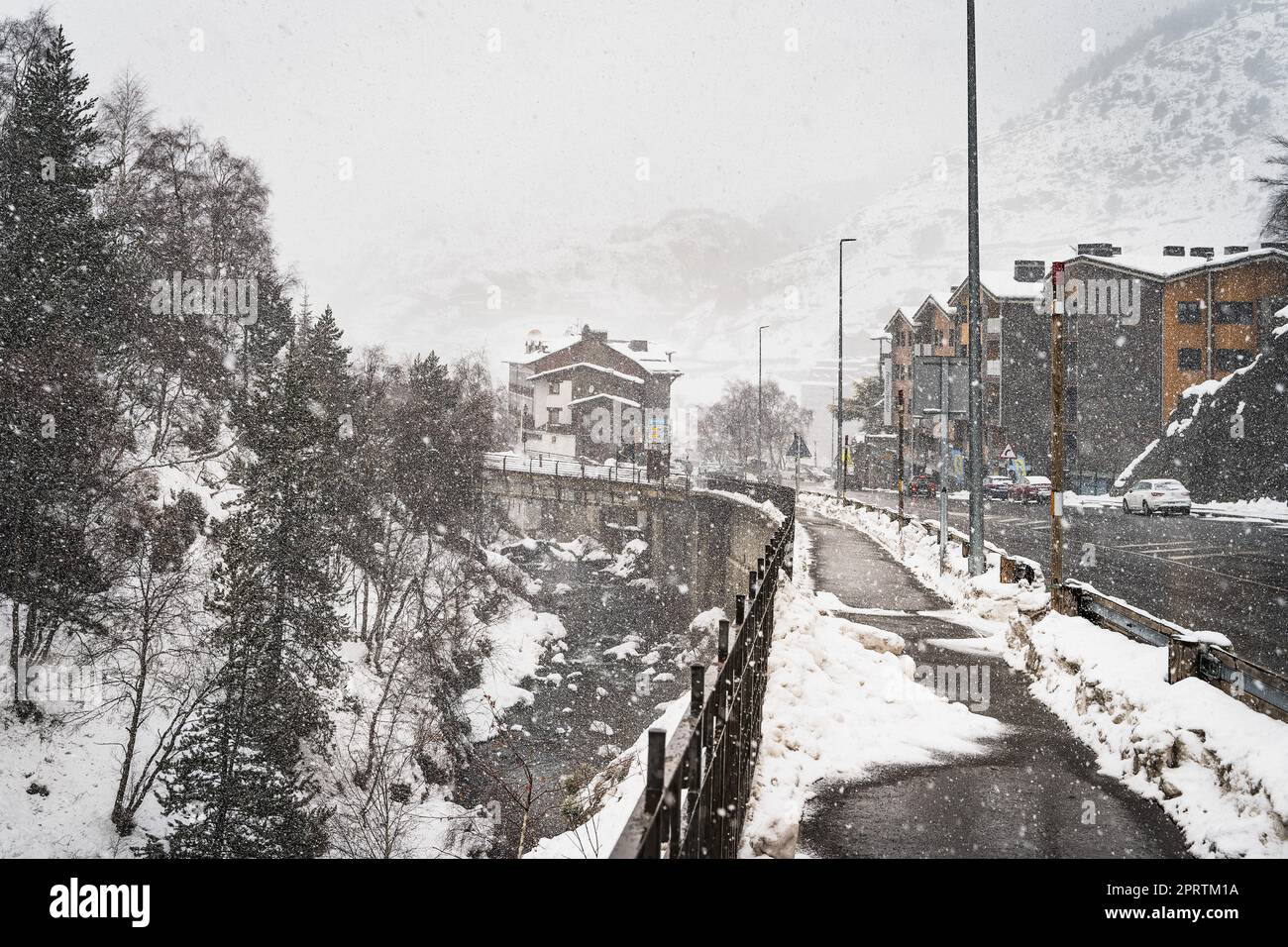 Forte caduta di neve nella città di El Tarter. Strada e marciapiede che conduce alla città e stazioni sciistiche nei Pirenei, Grandvalira, Andorra Foto Stock