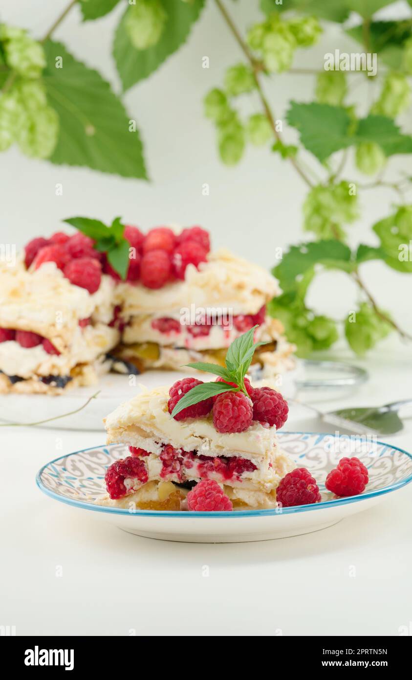 Torta di meringa rotonda con lamponi freschi su sfondo bianco, Pavlova dessert Foto Stock
