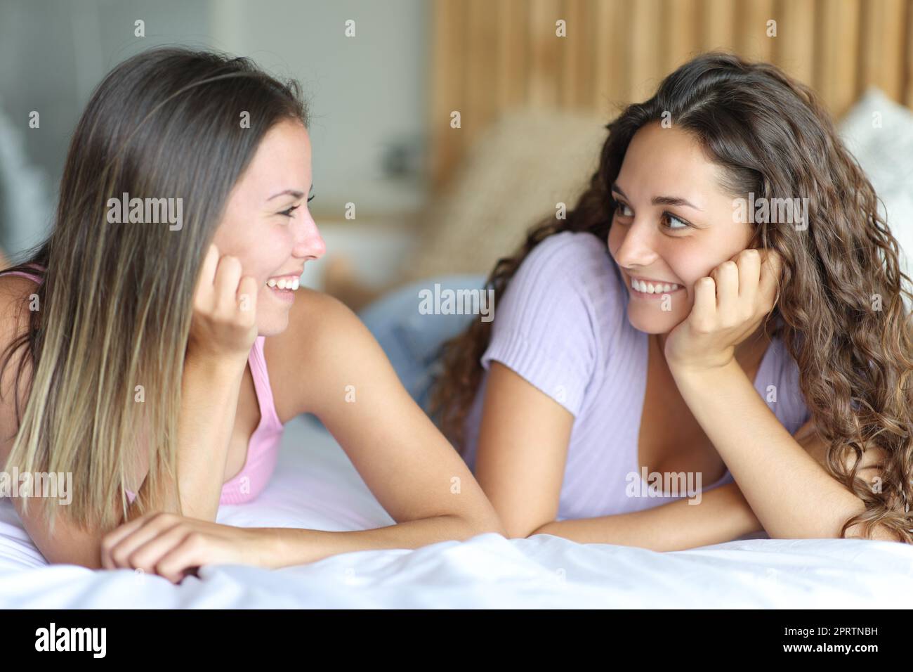 Donne felici che si guardano su un letto Foto Stock