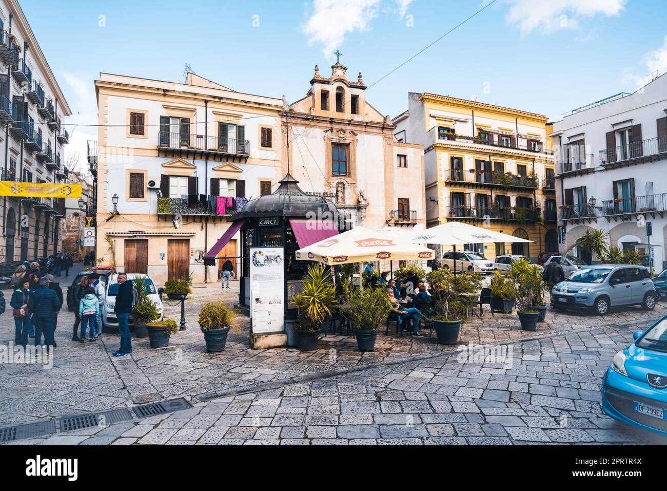 Una tipica piazza acciottolata nella storica Palermo con un piccolo chiosco davanti al quale si siede e si beve un caffè. Foto Stock