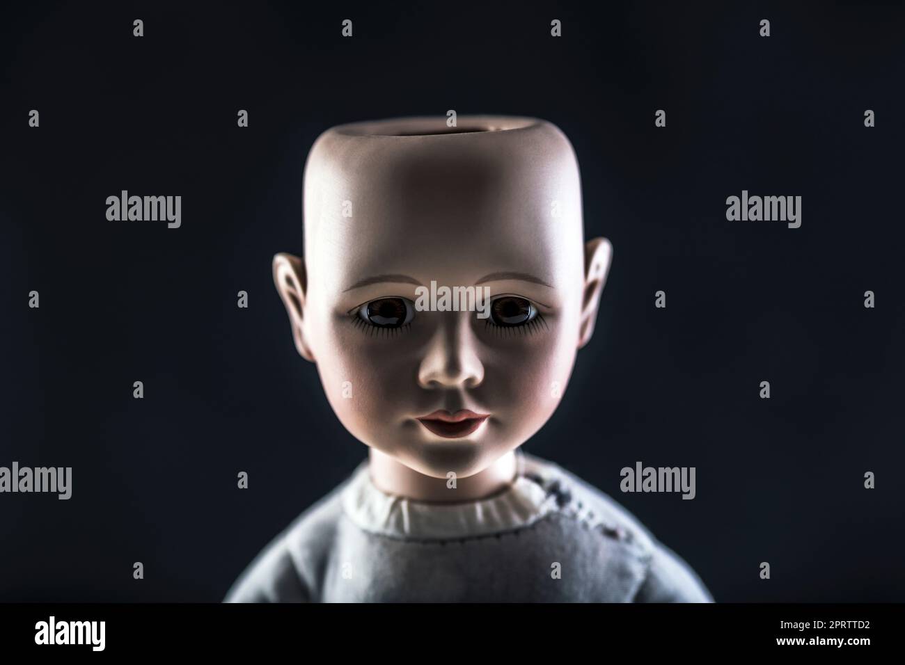 Faccia di bambola creepy su fondo scuro Foto Stock