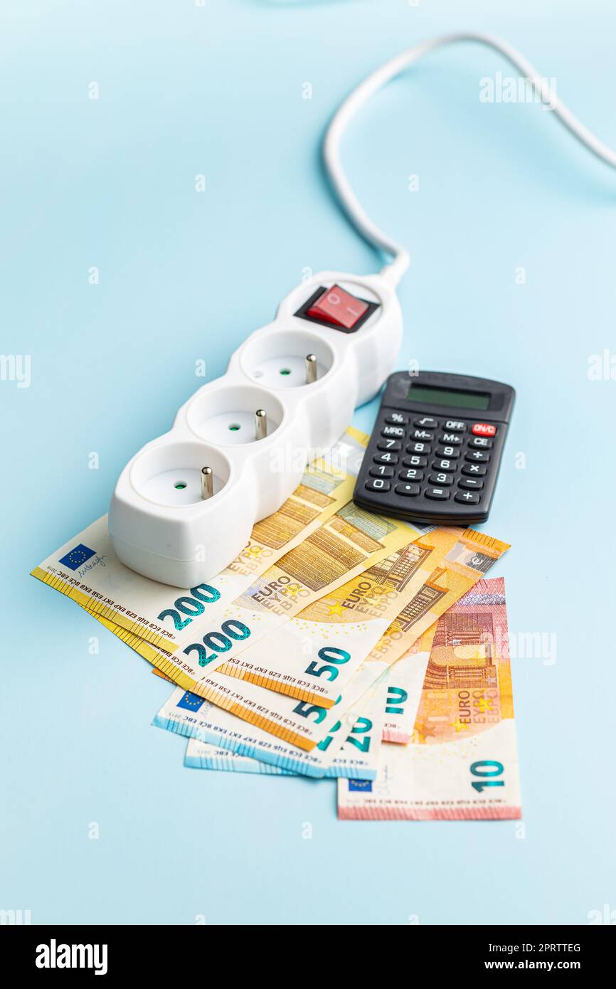 Presa elettrica, calcolatrice e euro money su sfondo blu. Foto Stock