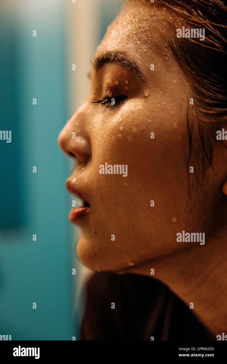 Atleta femminile con il sudore che sgocciola dal viso Foto Stock