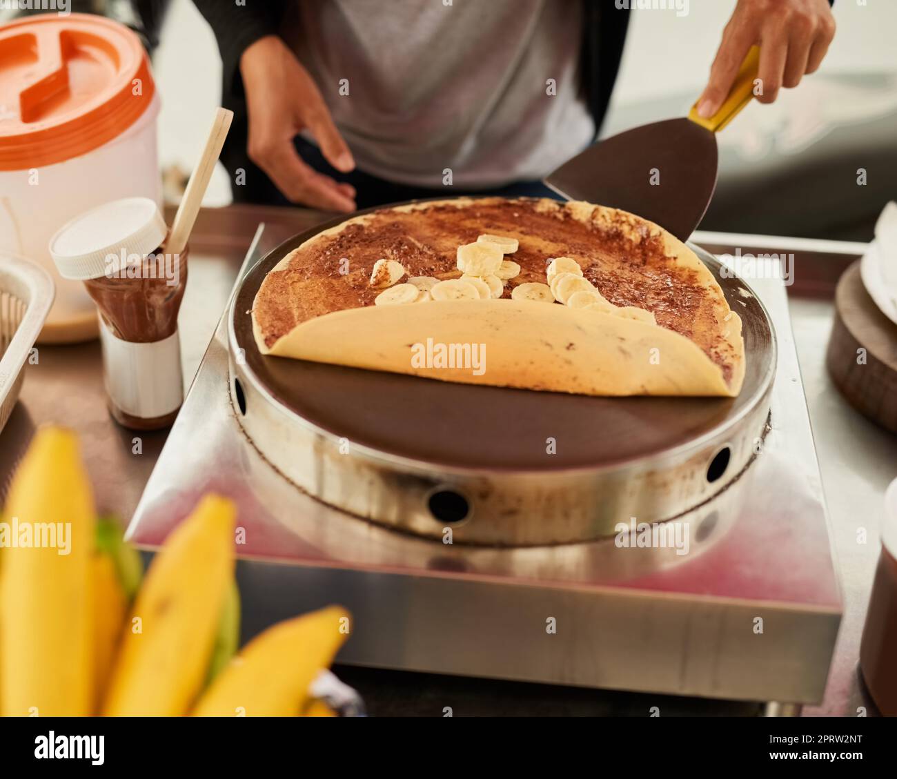 Pronti a soddisfare il vostro dolce desiderio. Un fornitore di cibo non identificabile in Thailandia che prepara uno snack gustoso Foto Stock