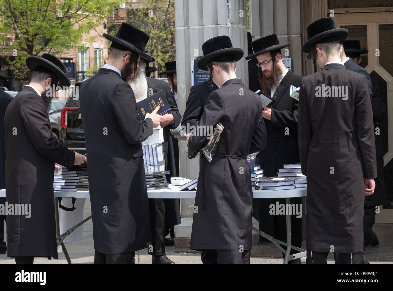 Uomini ebrei hassidici in una vendita di libri domenicale fuori da una sinagoga Satmar a Williamsburg, Brooklyn, New York. Foto Stock