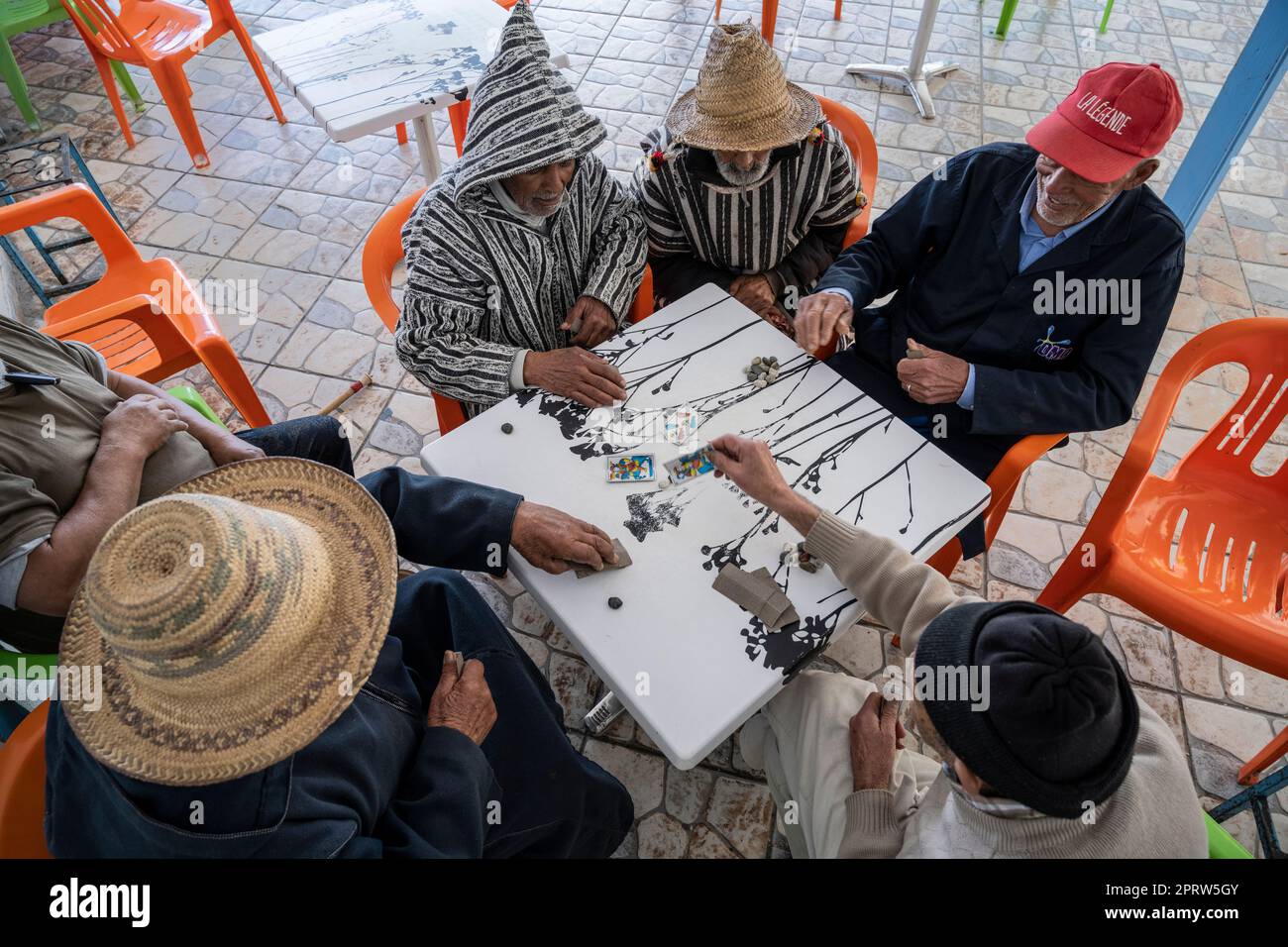Gruppo di uomini che giocano a carte sulla terrazza di un bar a Oued Laou. Foto Stock