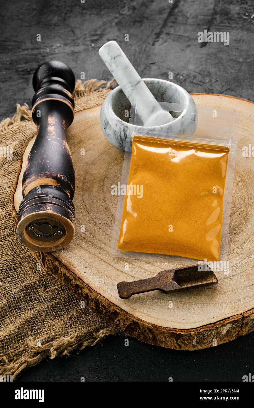 Sezione trasversale in legno con curcuma in confezione di plastica, Malta e fresa Foto Stock