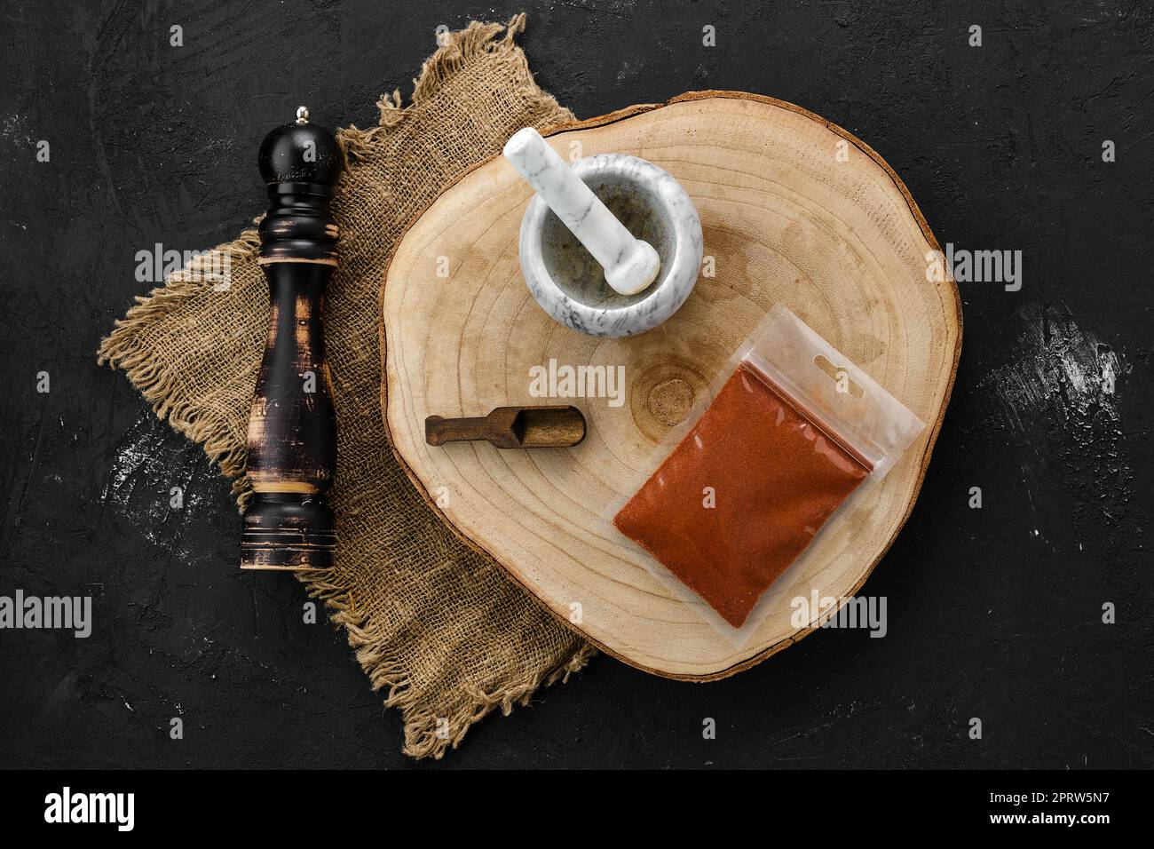 Sezione trasversale in legno con peperoncino in confezione di plastica, Malta e tritatutto Foto Stock