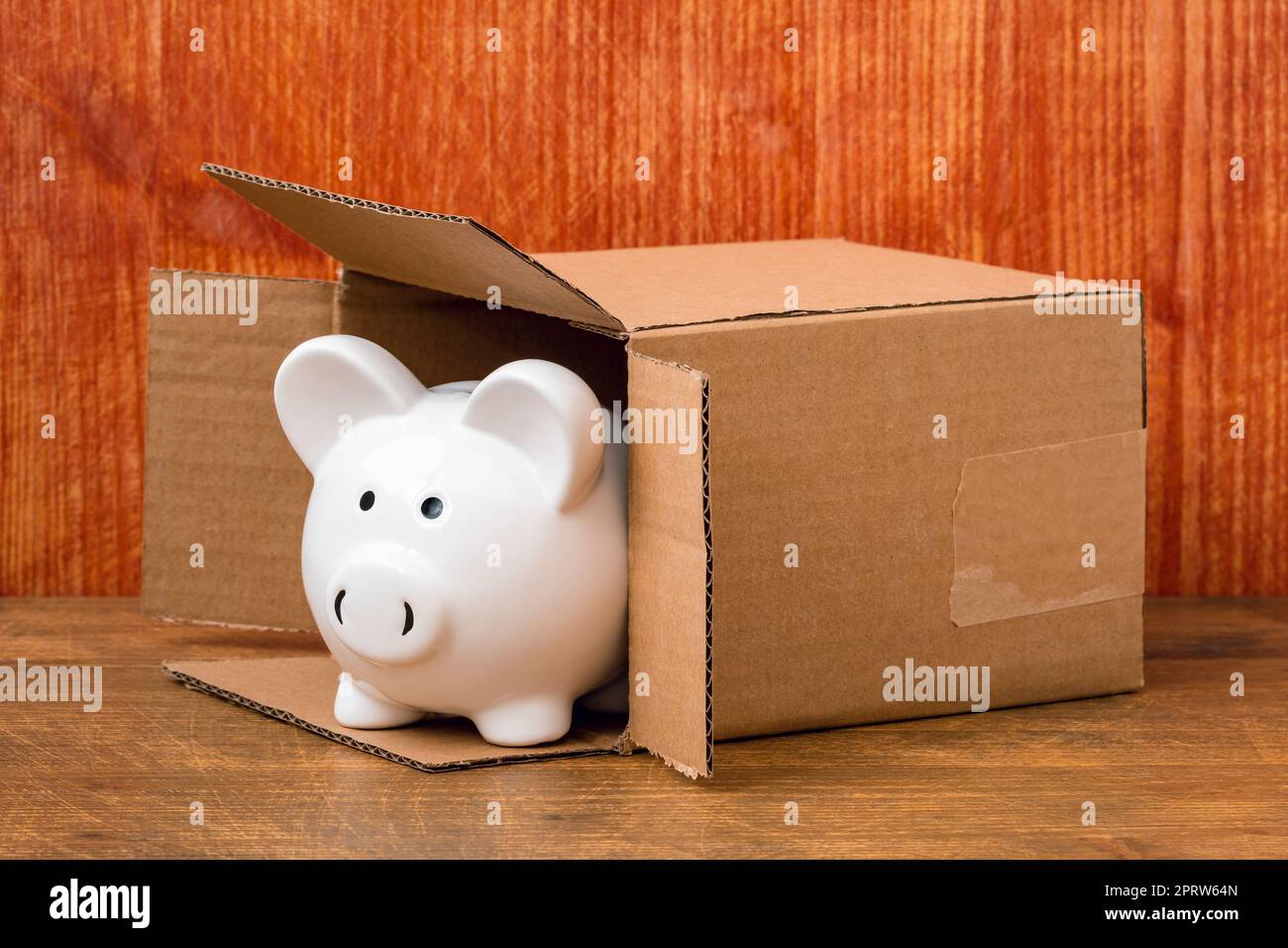 Il piggy bank esce dalla scatola di cartone Foto Stock