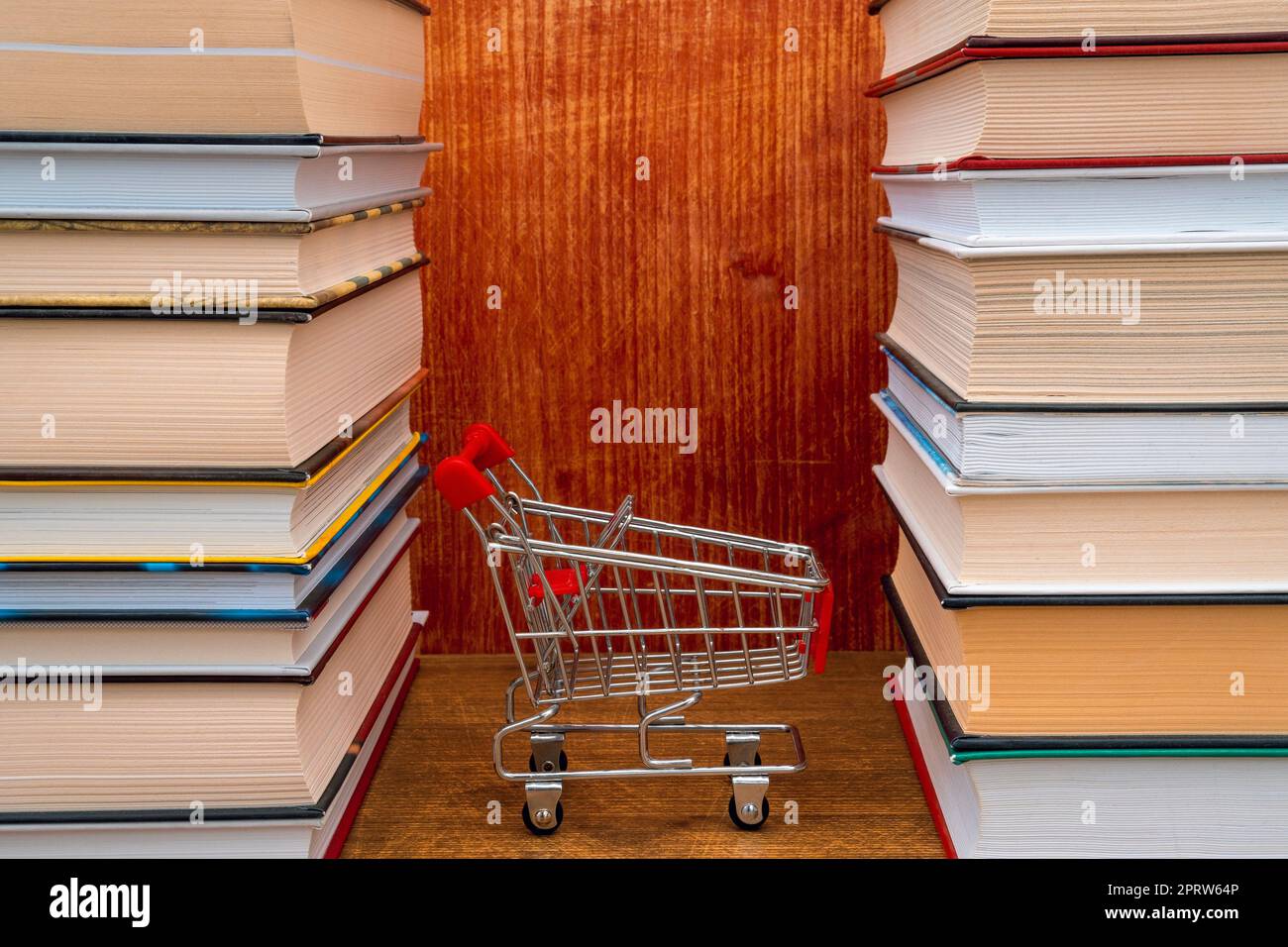 Un carrello vuoto tra i libri impilati Foto stock - Alamy