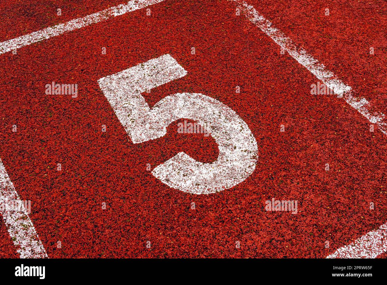 Il numero 5 al punto di partenza della pista da corsa o della pista da atleta nello stadio Foto Stock