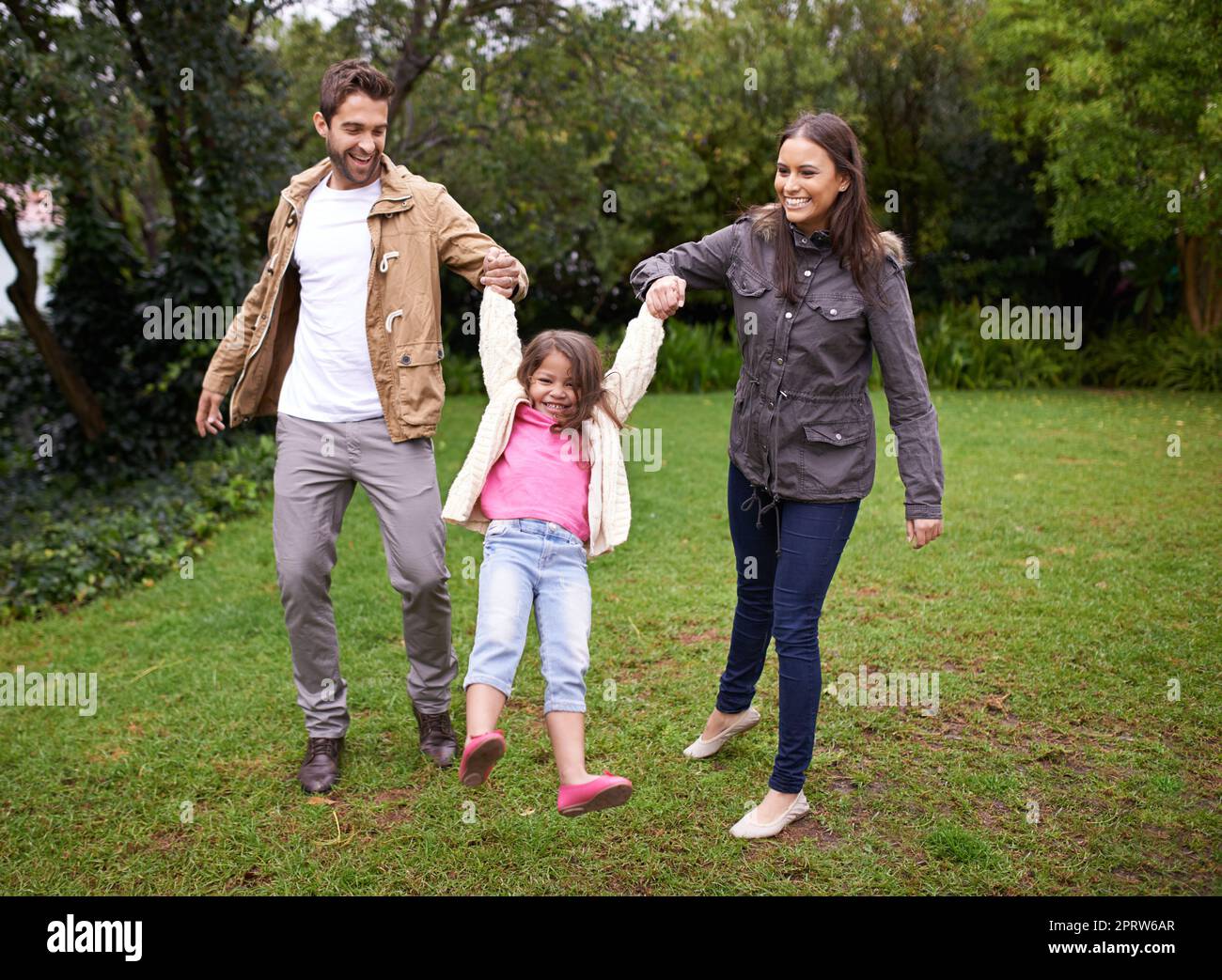 La famiglia è un dono che dura per sempre. Un ritratto corto di due genitori felici con la loro figlia giovane in piedi all'aperto. Foto Stock