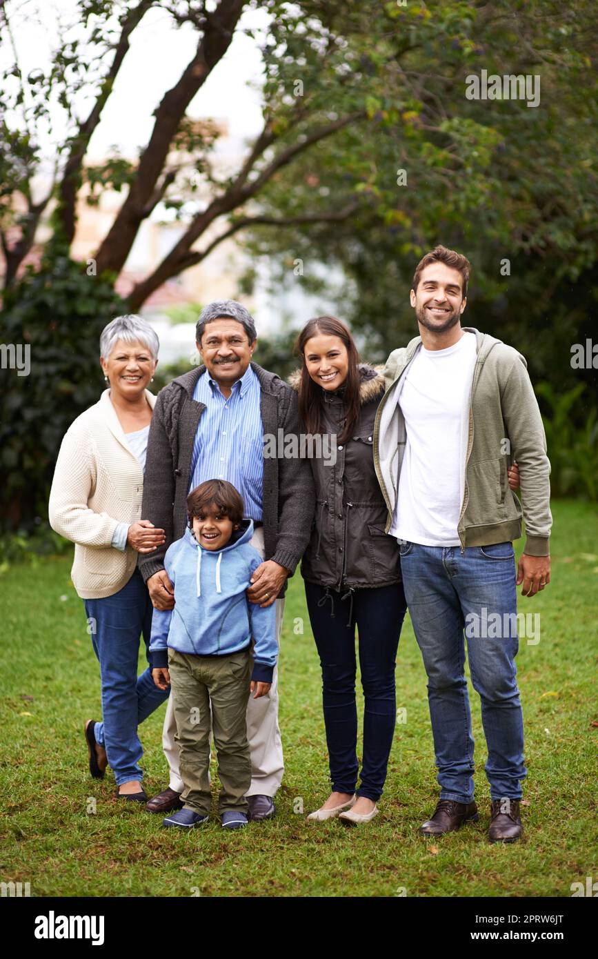 Legami speciali di famiglia. Ritratto completo di una famiglia multigenerazionale in piedi insieme all'esterno. Foto Stock