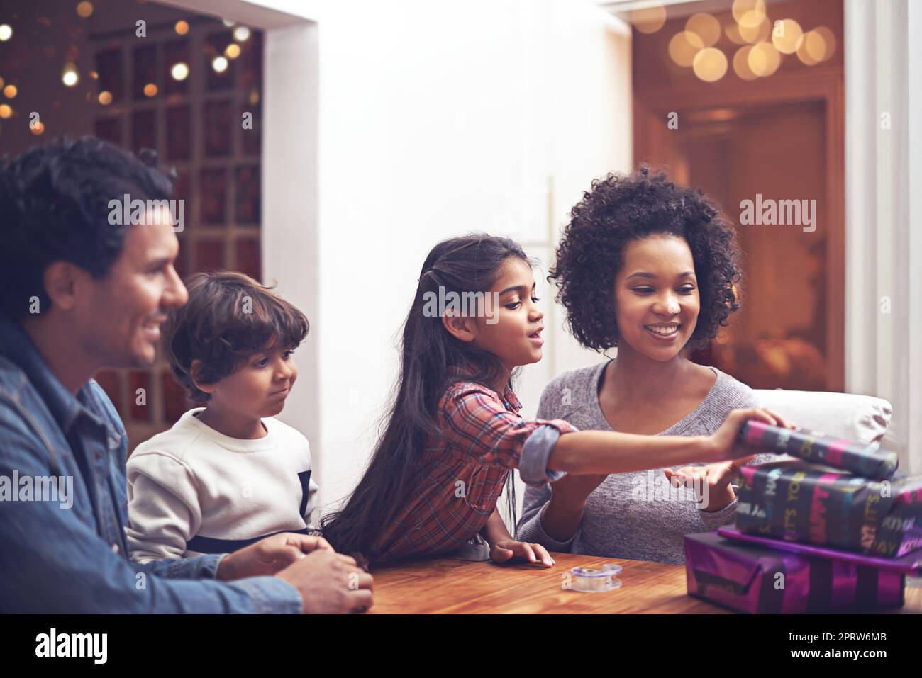 Tempo per i regali. Una famiglia seduta ad un tavolo con i regali. Foto Stock