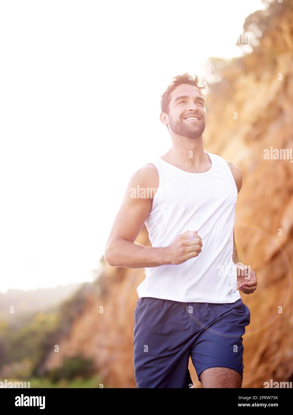 Tempo di jogging perfetto, un bel giovane che fa jogging all'aperto. Foto Stock