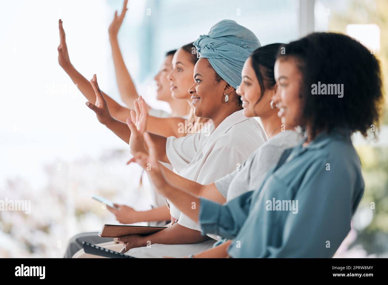 Le donne d'affari mettono in discussione le mani sollevate durante la formazione in workshop sulla diversità, l'inclusione e l'empowerment o le riunioni del team. Gruppo di persone o pubblico in un seminario convegno discussione con idee di sviluppo Foto Stock