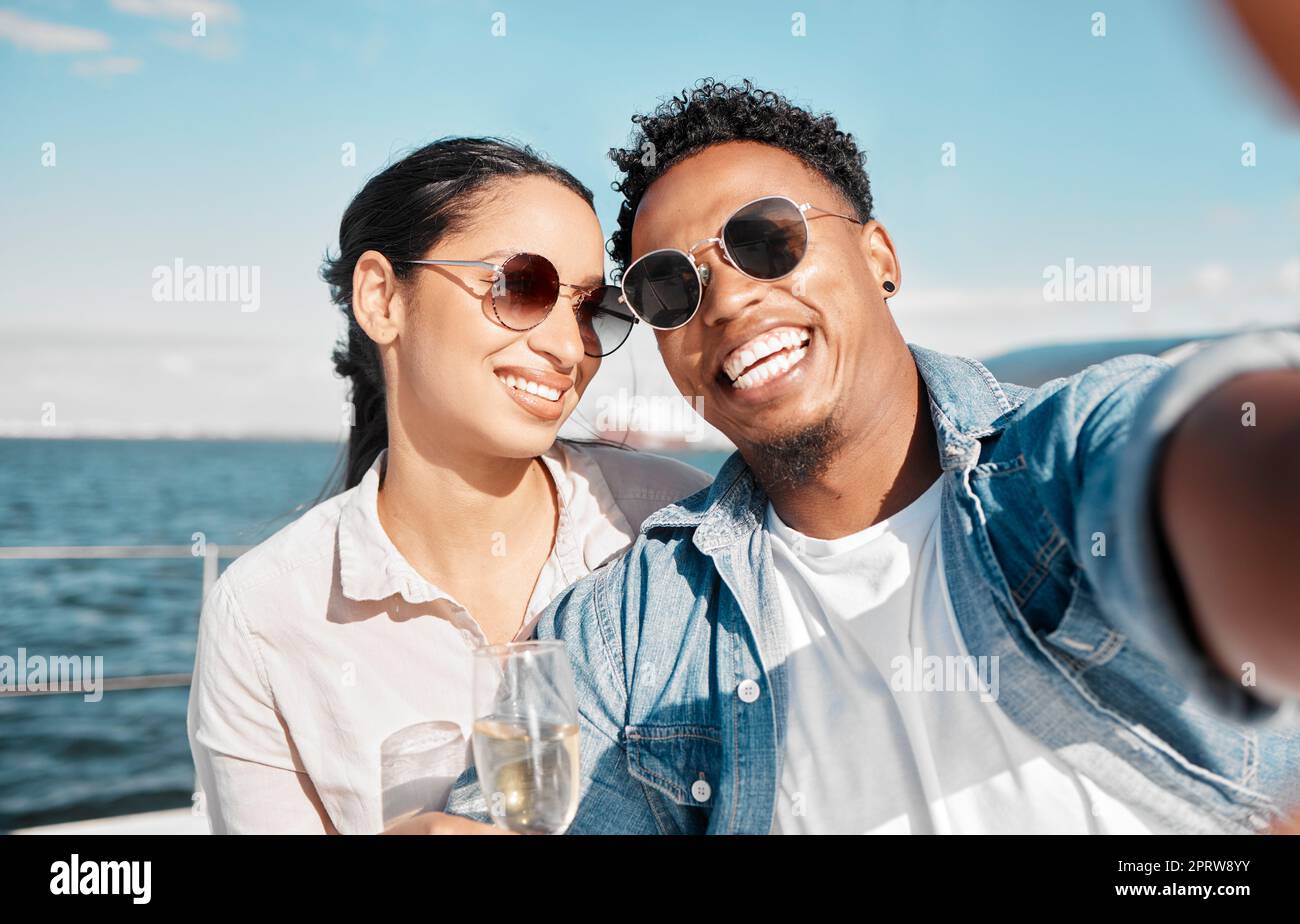 Selfie di coppia sullo yacht nell'oceano festeggiate con champagne in vacanza o in vacanza in estate. Felice giovane uomo con vino di lusso, crociera in mare con donna per festeggiare o viaggio di nozze sulla nave Foto Stock