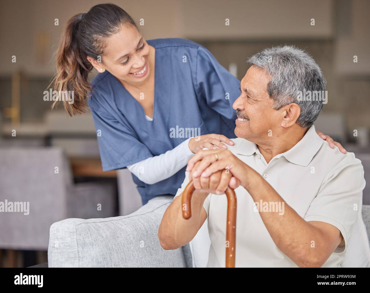 Assistenza sanitaria, gentilezza e supporto con l'infermiera che aiuta i pazienti anziani nella casa di riposo assistita, sorriso e contenuti. Uomo anziano felice che si unisce a un assistente cordiale, parla e ridi insieme sul divano Foto Stock